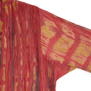 A detail of the sleeve of a dark pink and yellow pleated shirt.